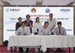 Figure 1: USAID / Vietnam Mission Director Aler Grubbs (standing, third from left), Chuong Tran, VNAH Board Members (far right) witnessed the project signing between representatives of VNAH (middle) and Bac Lieu government partners.